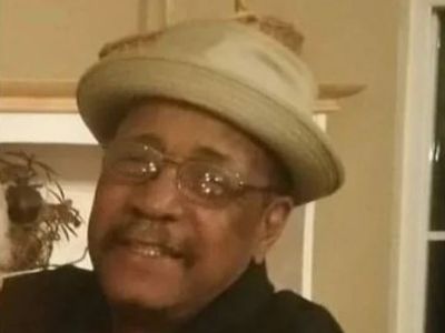 Reginald "Reggie" Grant is wearing a hat and glasses in the picture.